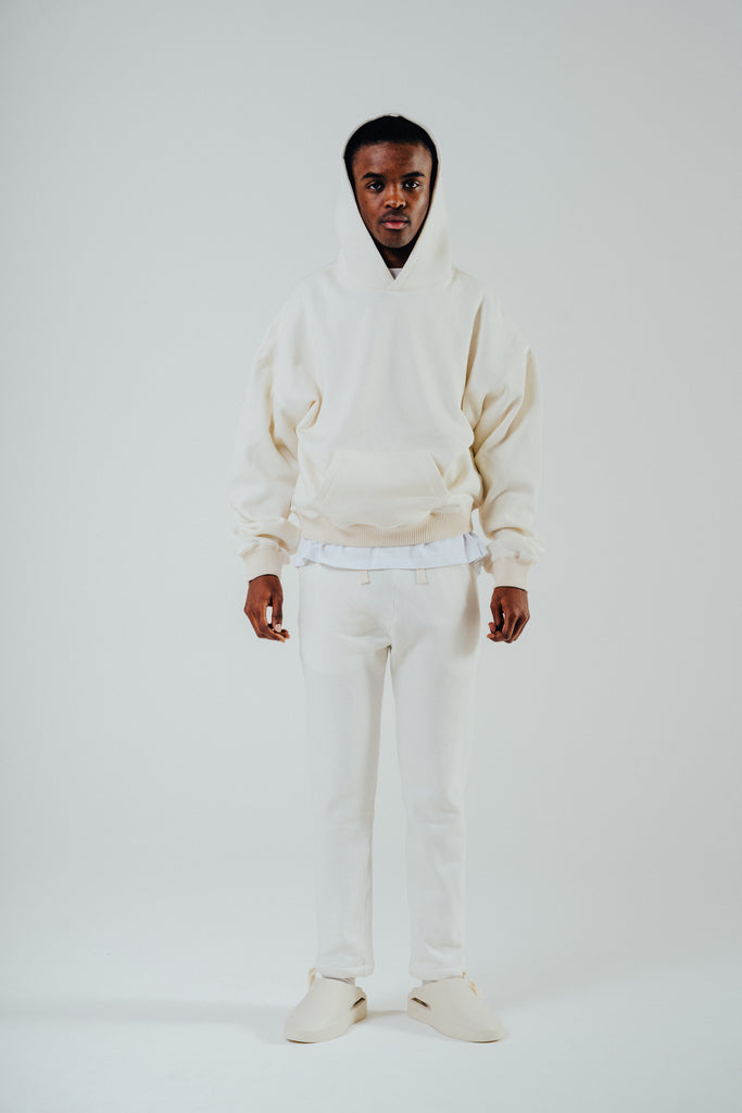 Model wearing an oversized boxy cream hoody with matching pants, showcasing a relaxed fit and cotton blend material.