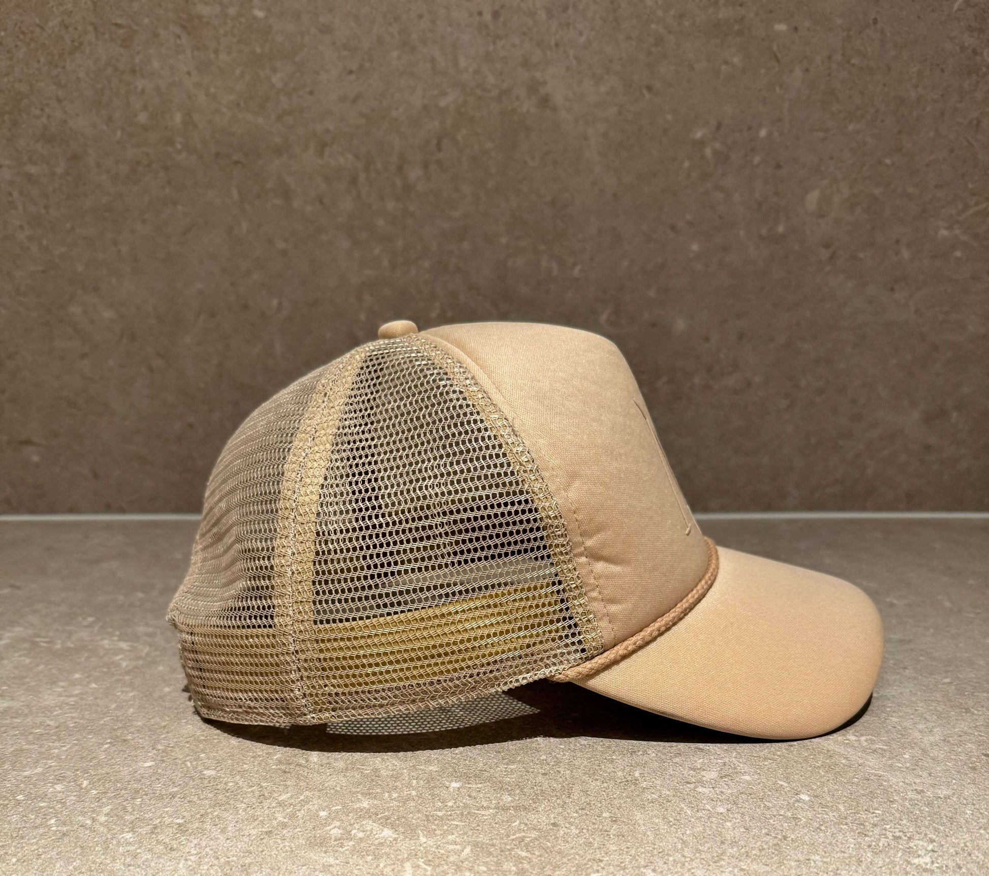 Side view of the taupe Mantle 2020 foam front trucker cap with adjustable snapback and mesh back.