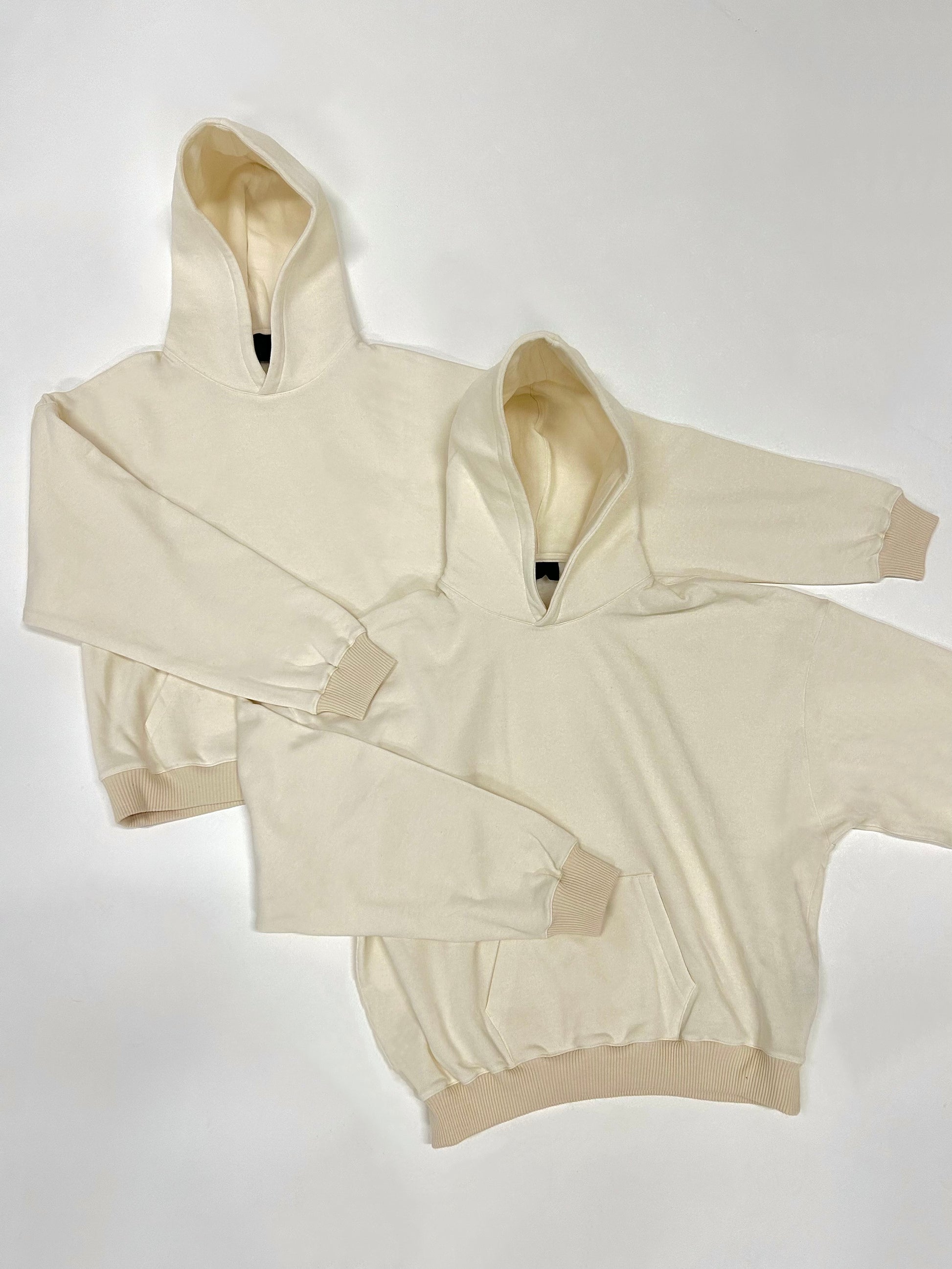 Relaxed oversized boxy hoody in cream colour with fused hood and ribbed cuffs, made from a cotton blend.