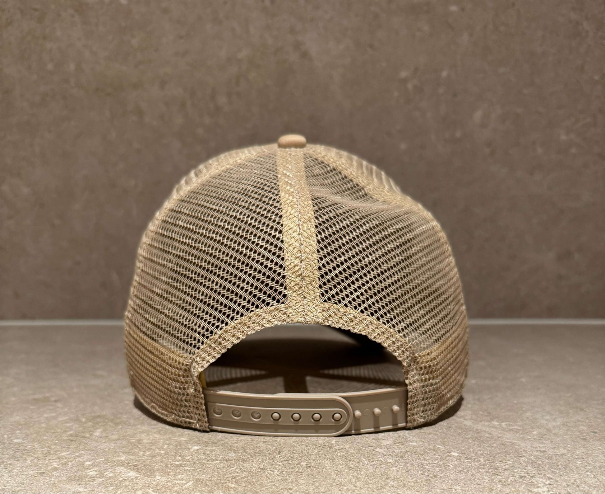 back view of taupe beige foam front trucker cap with snapback closure and mesh detailing.