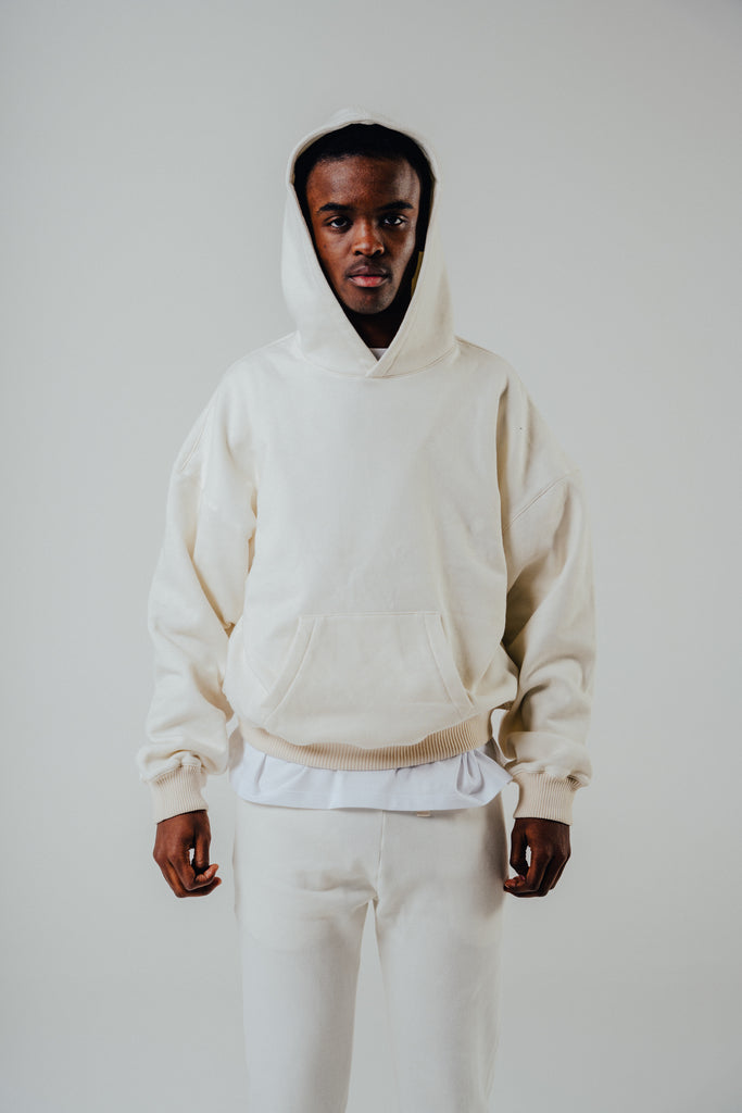 Oversized boxy hoody in cream heather colour with kangaroo pocket, model wearing size small, cotton blend fabric.