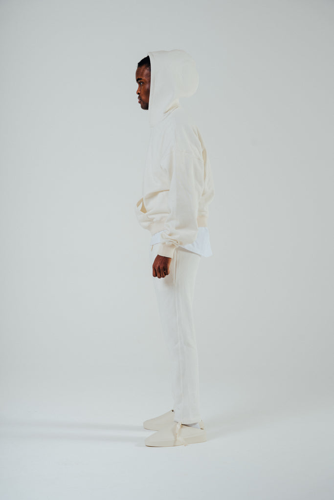 Oversized boxy hoody in cream colour worn by model, showcasing fleeceback cotton blend for comfort and style.