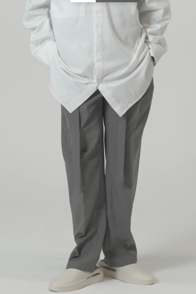 Tailored rope belt trousers in grey displayed on model, featuring relaxed fit and popper button at ankle.