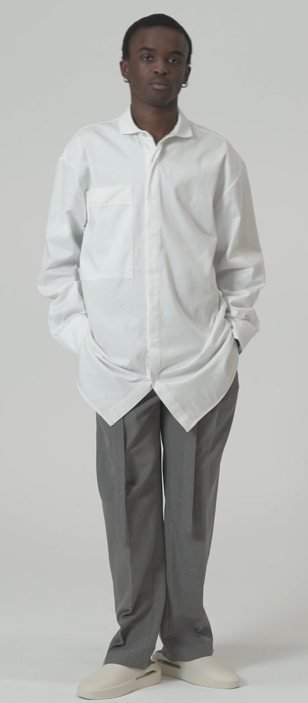 Model wearing tailored rope belt trousers in grey, paired with a white oversized shirt, showcasing a relaxed fit style.