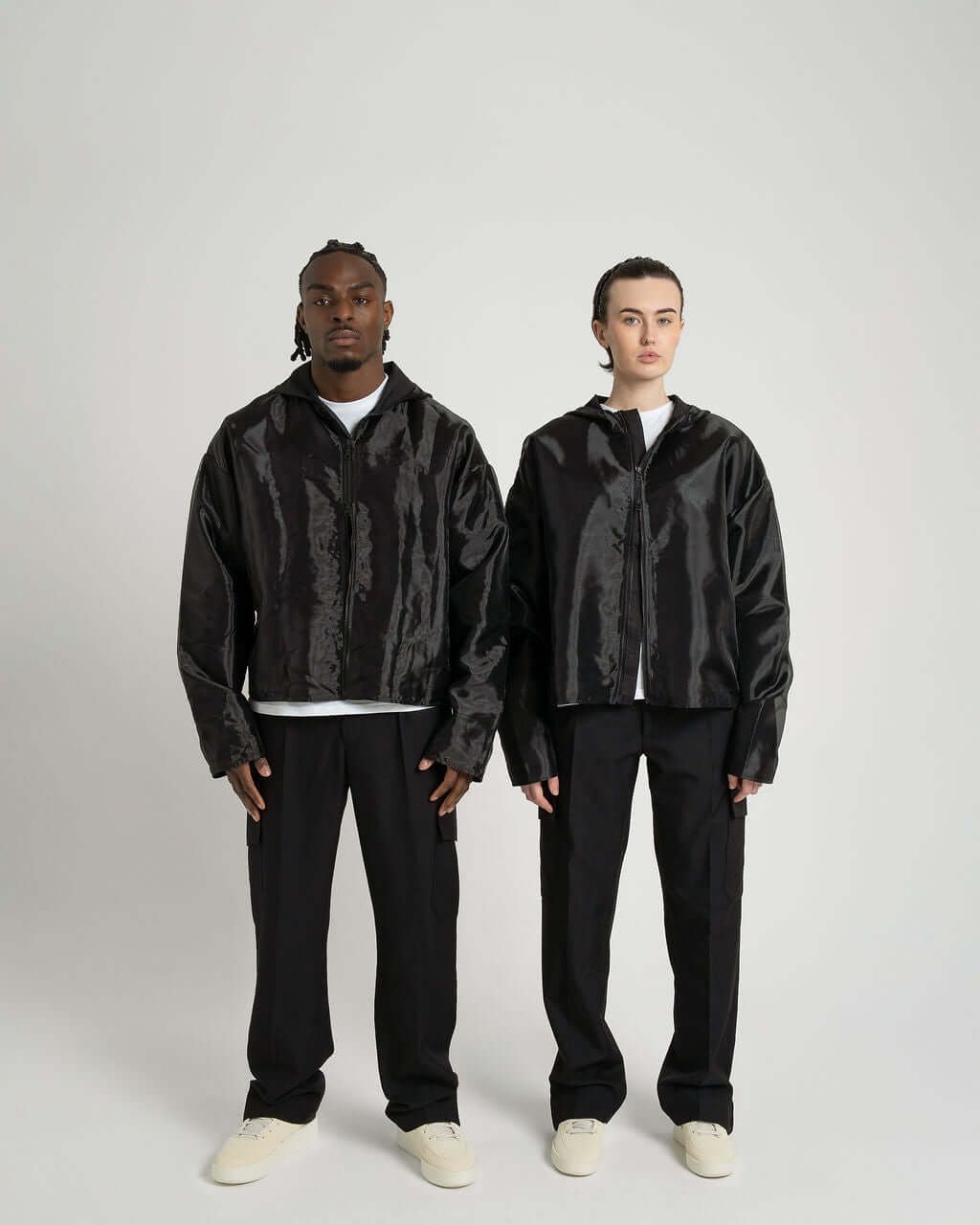 Models wearing the 'Virgil' Organza hooded zip up jacket in black, showcasing an oversized fit and cropped design.