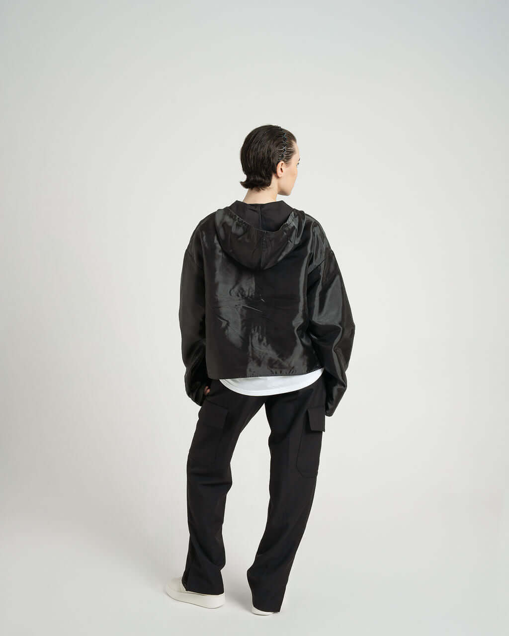Model wearing oversized black "Virgil" organza hooded zip up jacket, showcasing cropped design and tonal YKK zip.