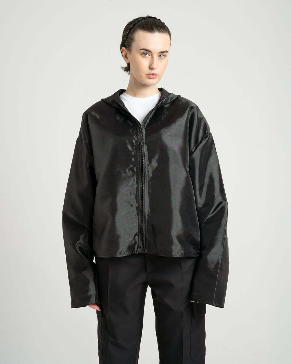 Model wearing the "Virgil" black organza hooded zip-up jacket, featuring an oversized fit and cropped design.