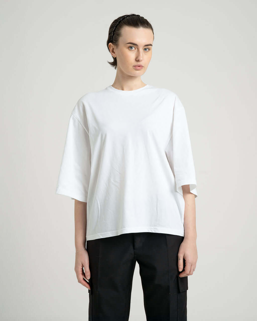 Model wearing a white boxy cropped tee made from lightweight cotton, showcasing comfort and style.
