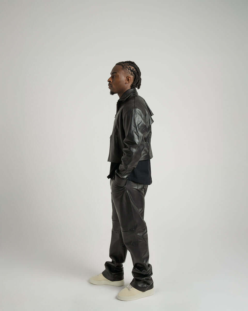 Model in a cropped black leather jacket, showcasing a stylish, boxy fit with a soft suede texture.