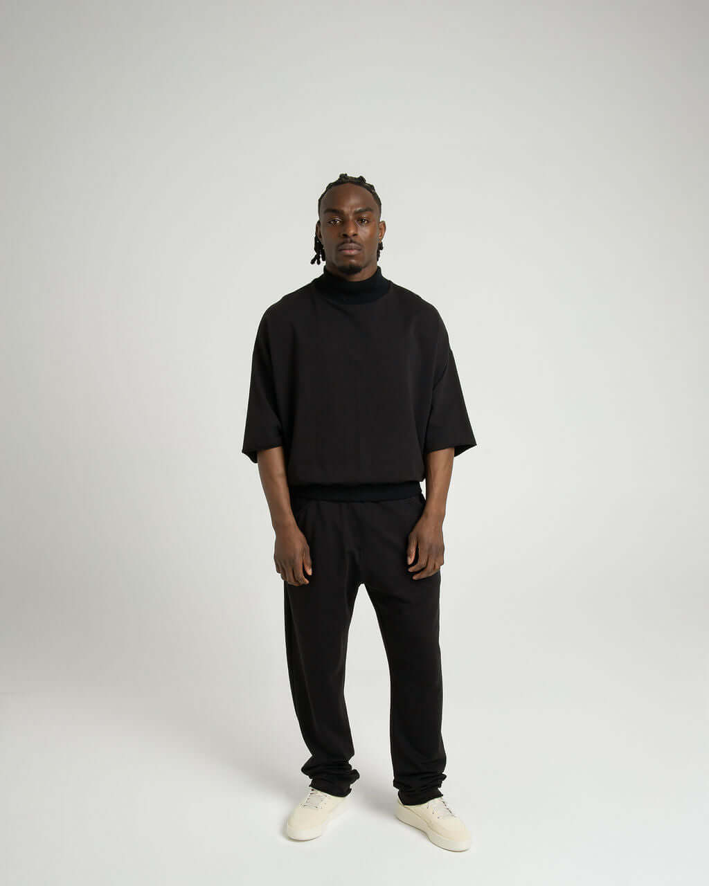 Model wearing a black 3/4 sleeve mock neck terry sweatshirt with matching pants, showcasing an oversized fit.