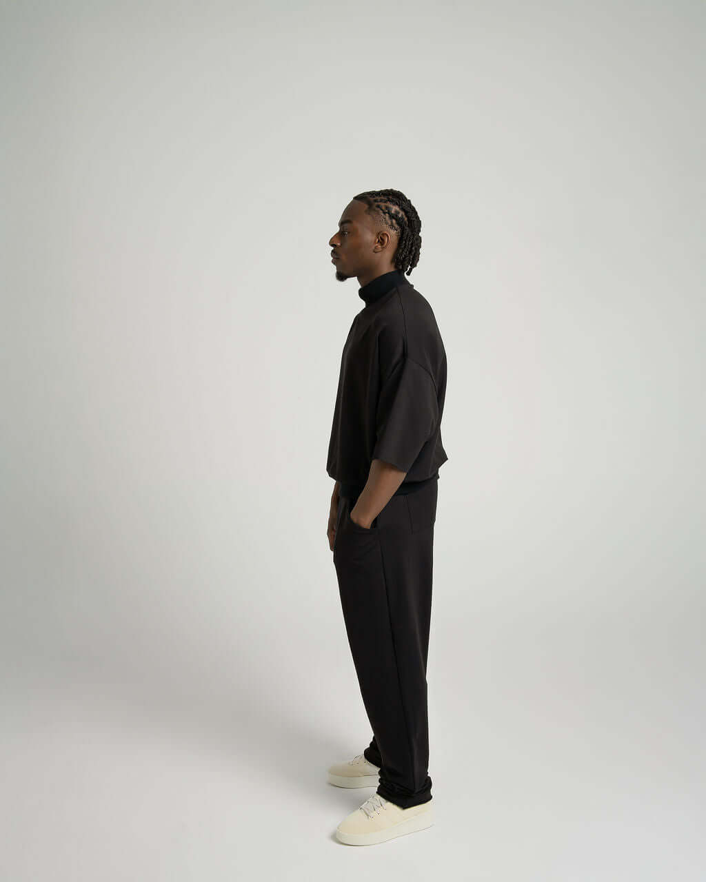 Model wearing a black 3/4 sleeve mock neck terry sweatshirt with relaxed fit and matching pants.