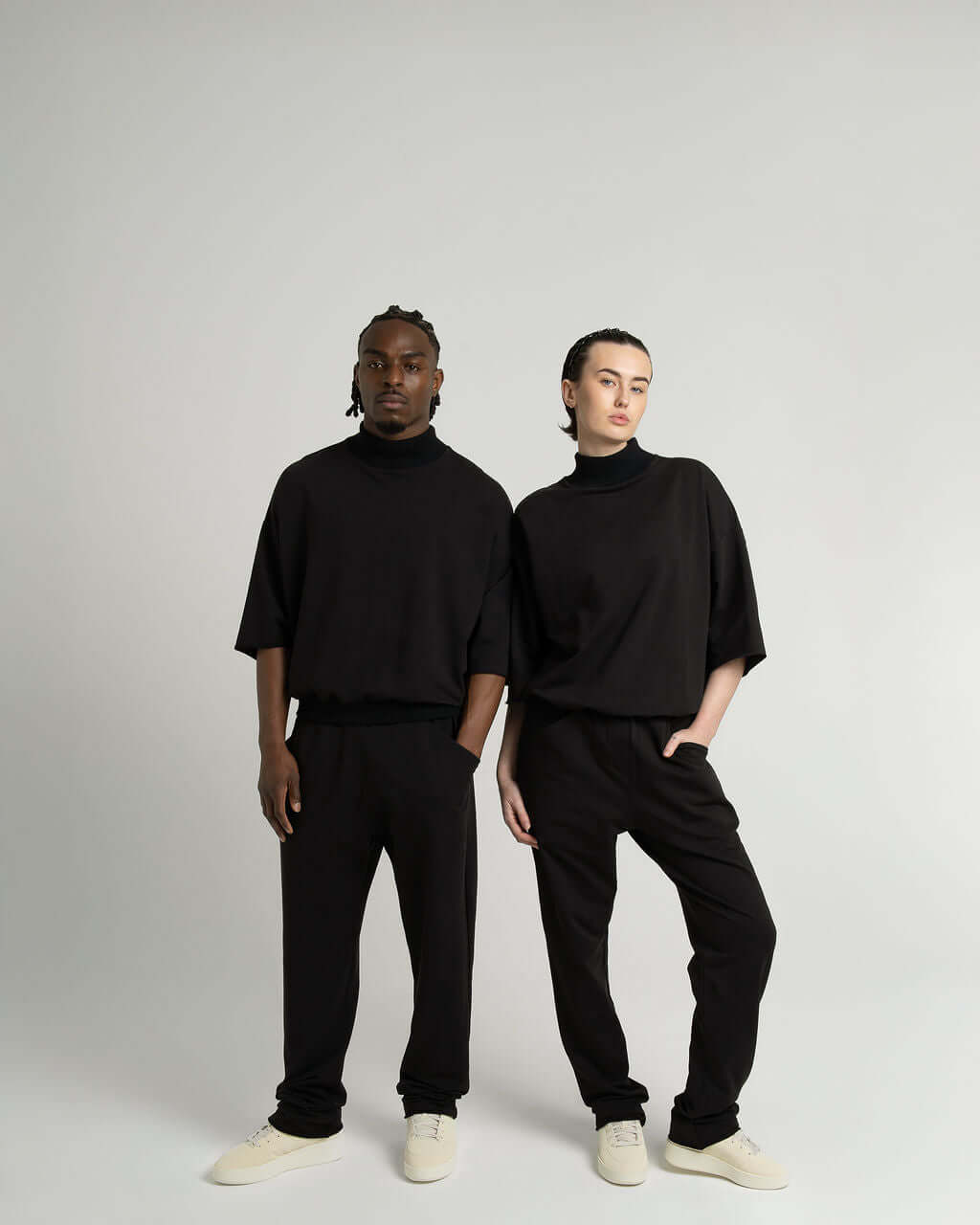 Modeling 3/4 sleeve mock neck terry sweatshirt in black, paired with relaxed pants, showcasing an oversized fit.
