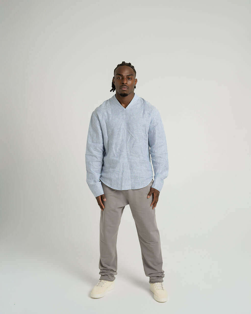 Model wearing a blue and white striped linen long sleeve pullover shirt with V-neck and relaxed fit.