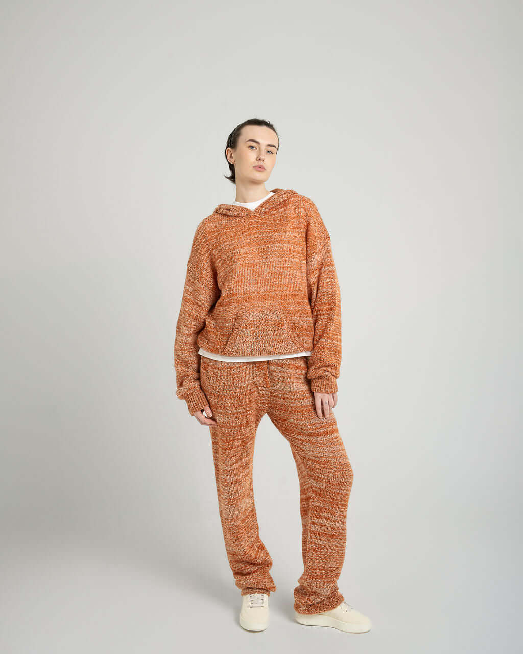 Model wearing Kid Mohair Blend Knitted Trousers and hoodie in Evening Sun, showcasing loose fit and unique knitted texture.