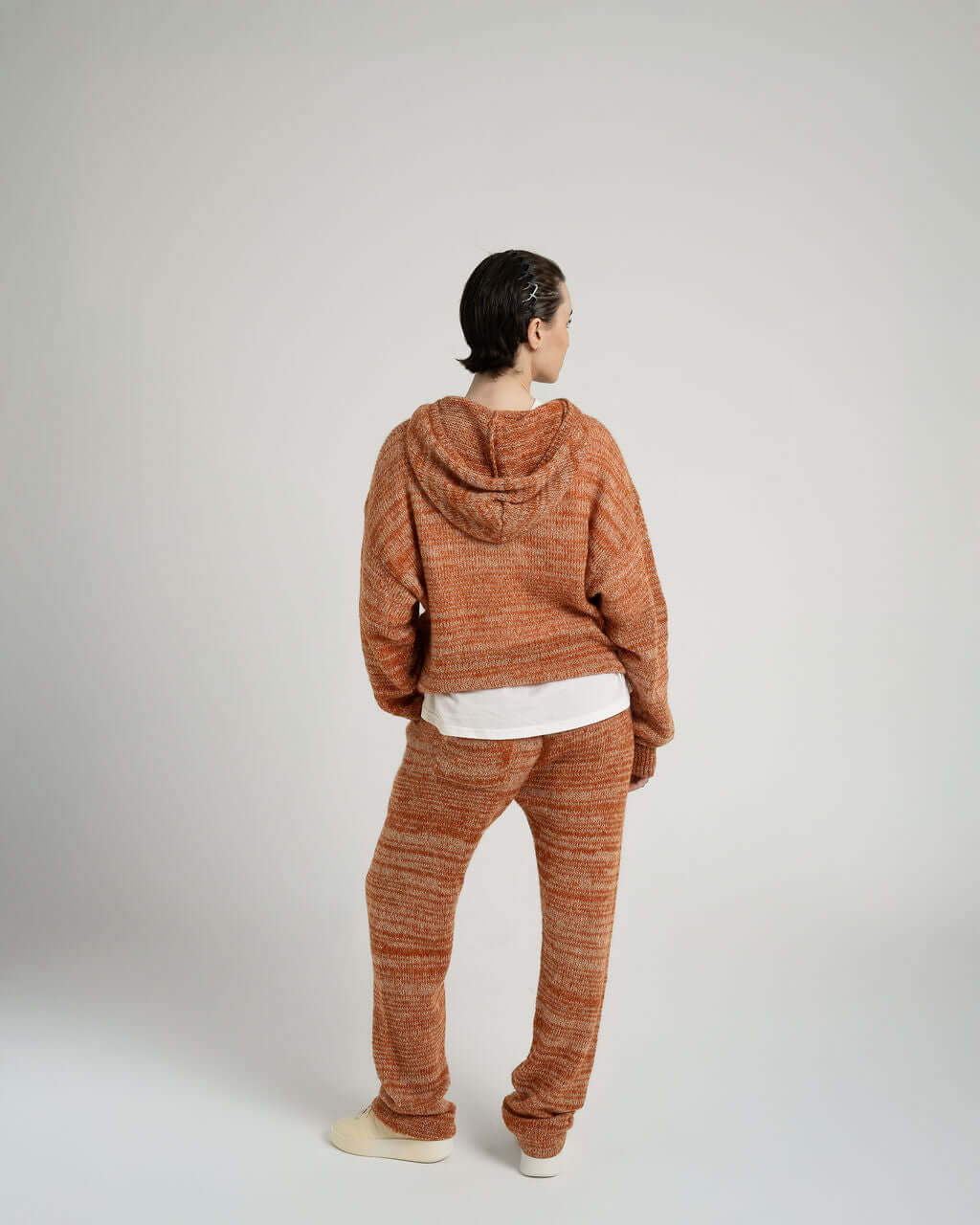 Model wearing Kid Mohair blend knitted trousers and hoodie in Evening Sun, showcasing oversized fit and unique yarn effect.