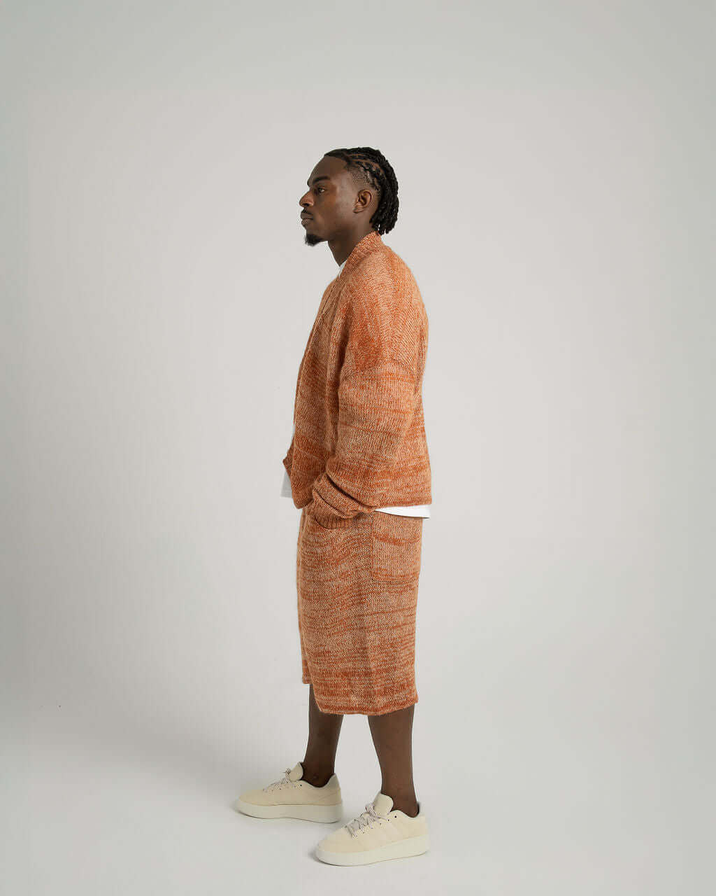Model wearing Kid Mohair blend knitted shorts and matching jacket in warm orange tones.