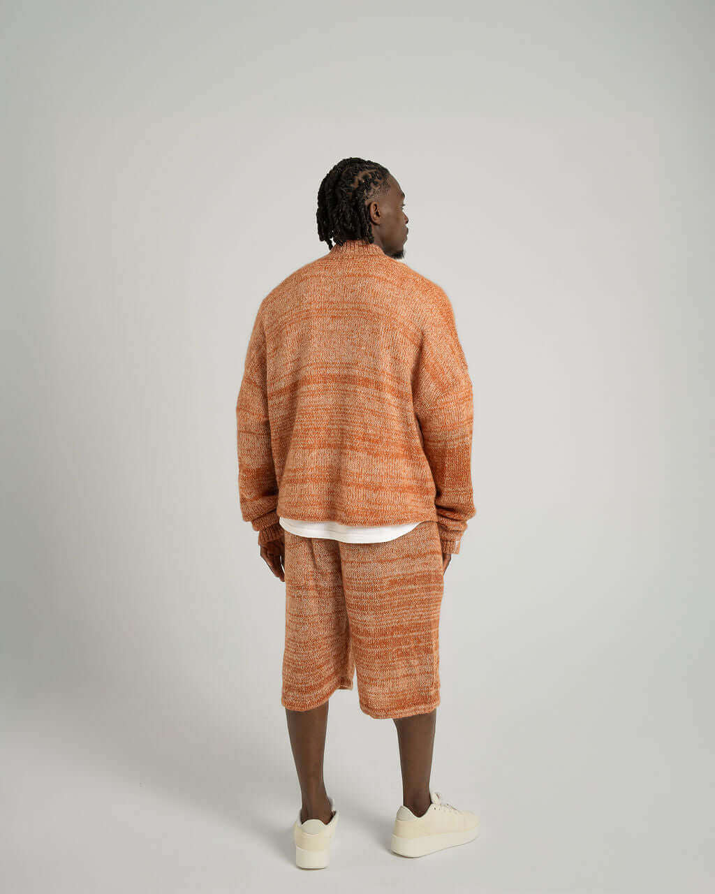 Model wearing Kid Mohair Blend Knitted Shorts in evening sun, styled with an oversized sweater, showcasing a relaxed fit.