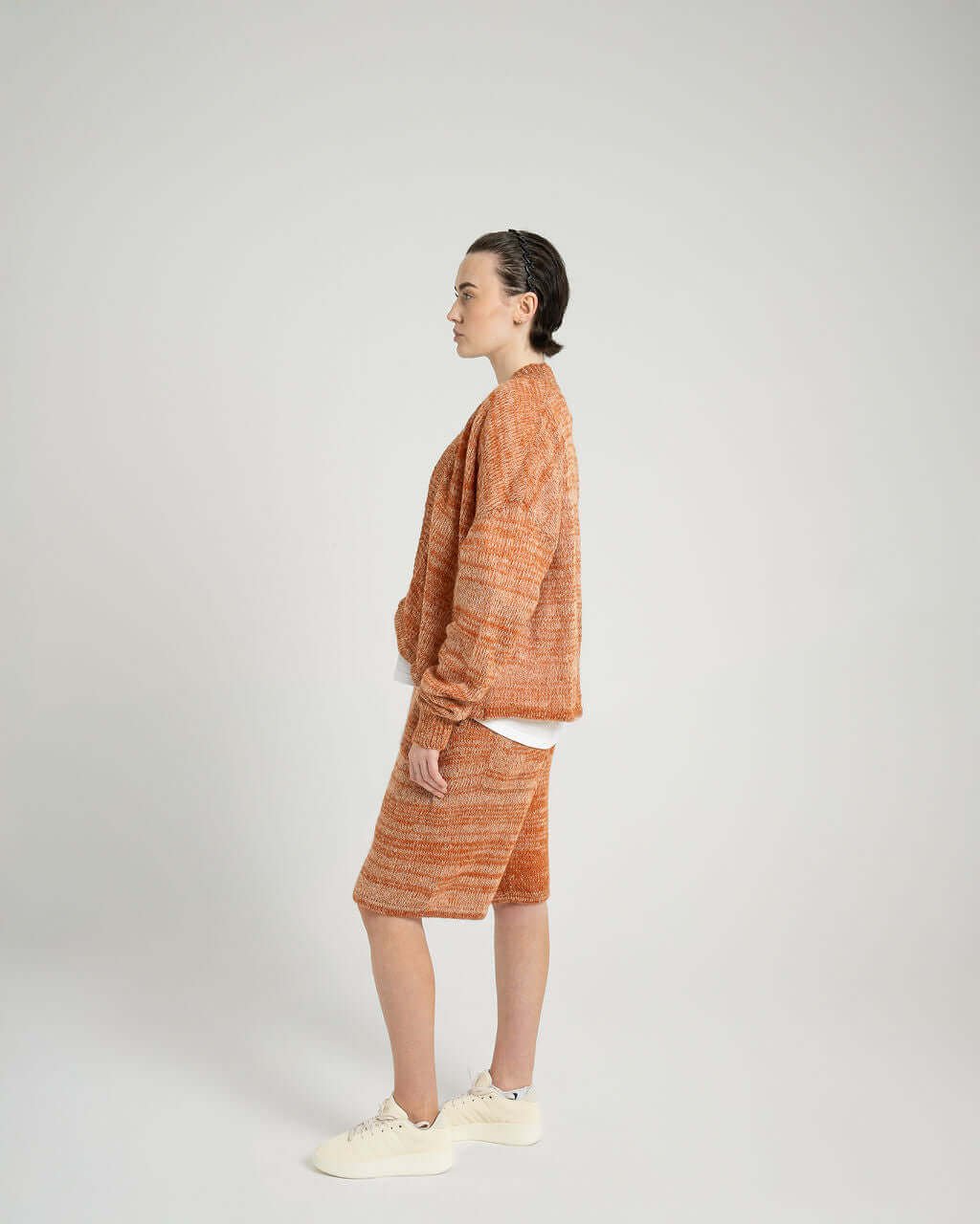 Model showcasing Kid Mohair blend knitted shorts and matching oversized sweater in sunset orange.