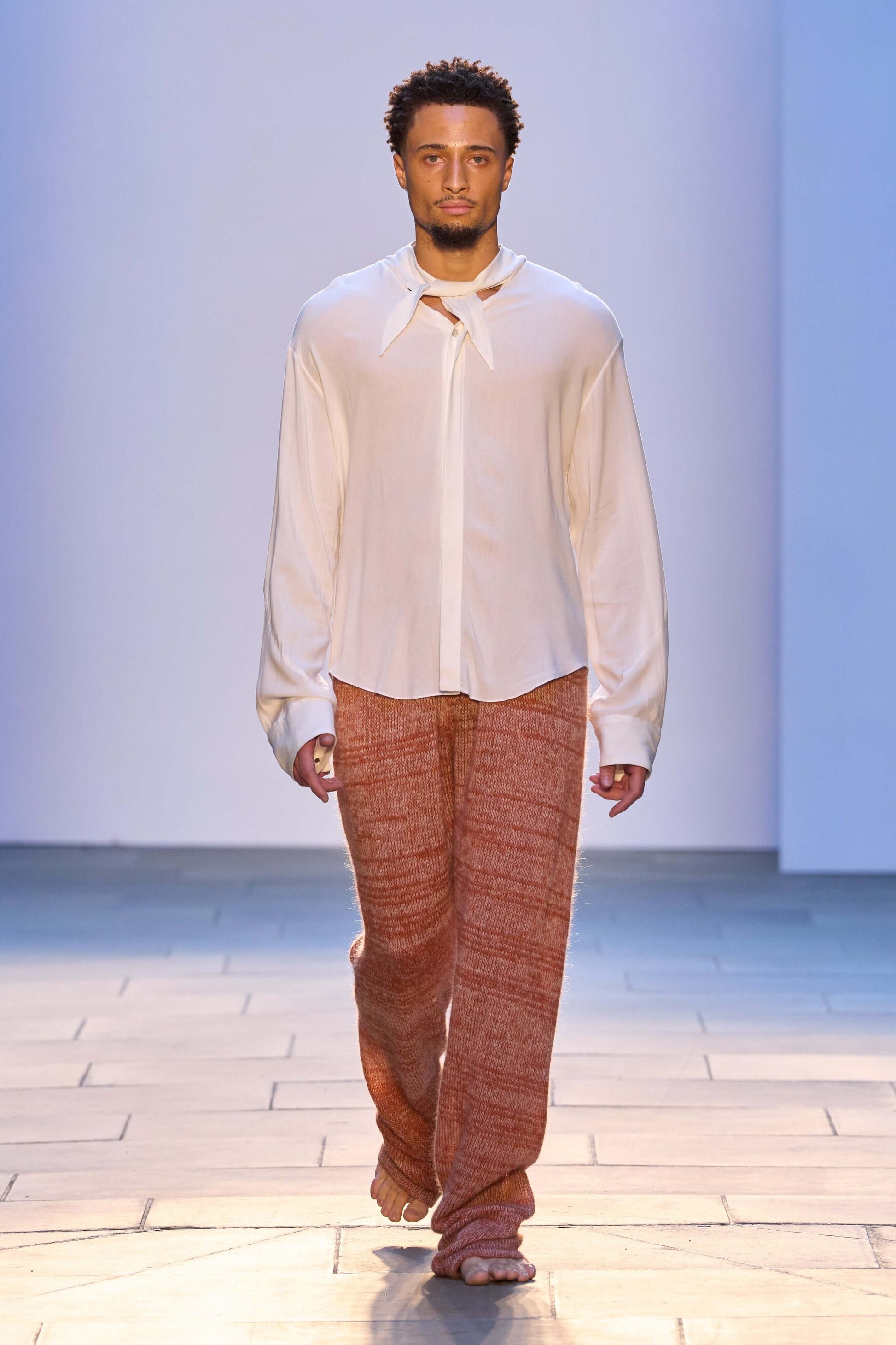 Model wearing Kid Mohair Blend Knitted Trousers in Evening Sun, featuring a loose fit and unique yarn texture.