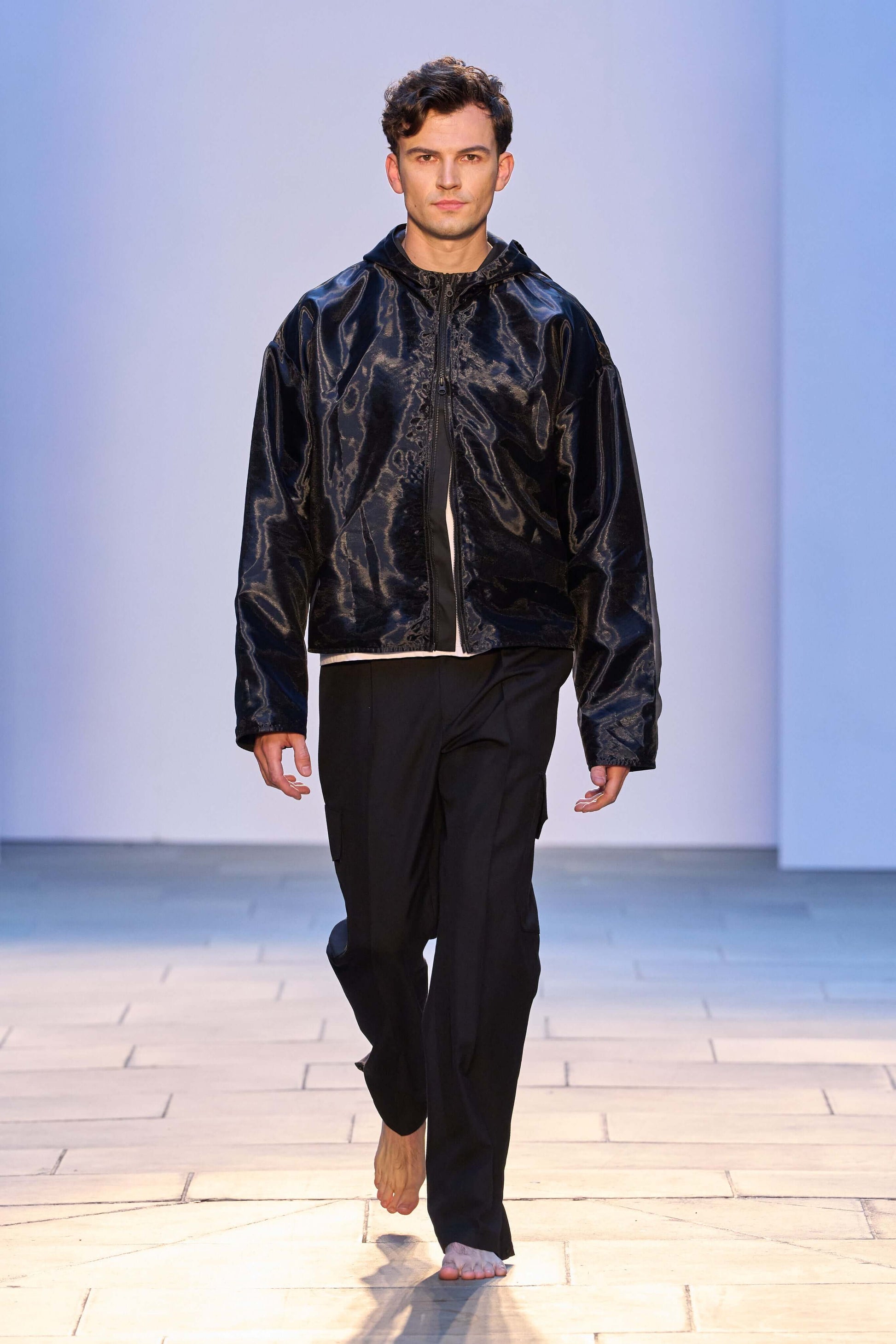 Model wearing the 'Virgil' black organza hooded zip-up jacket, showcasing an oversized fit and cropped design.